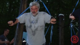 Herr im Wald beim funktionellen Krafttraining im alter, und dem ausführen einer TRX Liegestütze